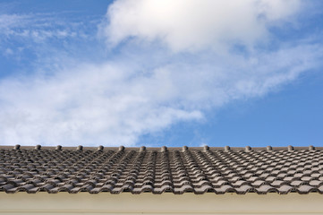Black tile roof on a new house with blue sky background