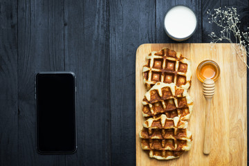 waffles with honey and milk on a black background.Homemade Waffles, Belgian waffles with honey and milk, food styling...