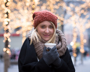 Young attractive woman holding a coffee cup in a winter day