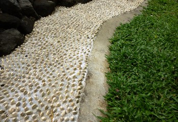 decorated garden pavement with a round white stones and green grass