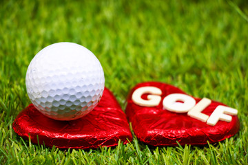 Naklejka premium Golf ball with heart shape and golf lettering on green grass