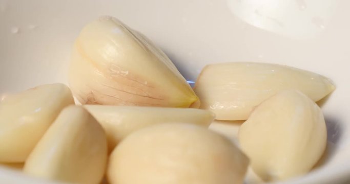 Skinned garlic on a dish.