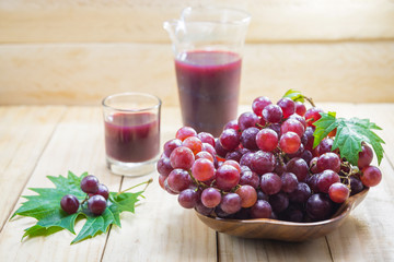 Fresh red grapes isolated on wooden background...