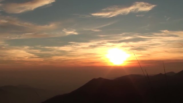 Fiery sunset from mountain pick with thin glazes in the sky evening. Fall season. Orobie alps. Rena pick. Bergamo Italy. 