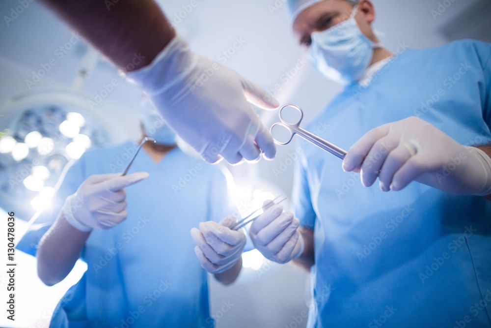 Poster group of surgeons performing operation in operation room