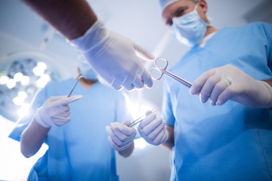 Group of surgeons performing operation in operation room