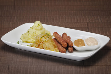 Homemade sausage with mashed potato and sauerkraut and mustard w