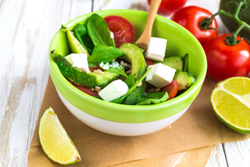 Green salad with avocado, tomatoes, spinach, lime and spices