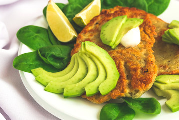 Potato fritters  with sliced avocado, spinach and lime.
