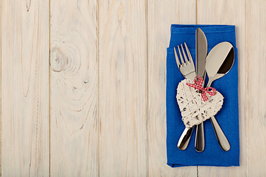 Valentine's day concept. On the wooden table cutlery on linen na