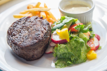 filet mignon with a side dish of vegetables