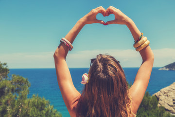 Girl holding a heart shape for the summer time.
