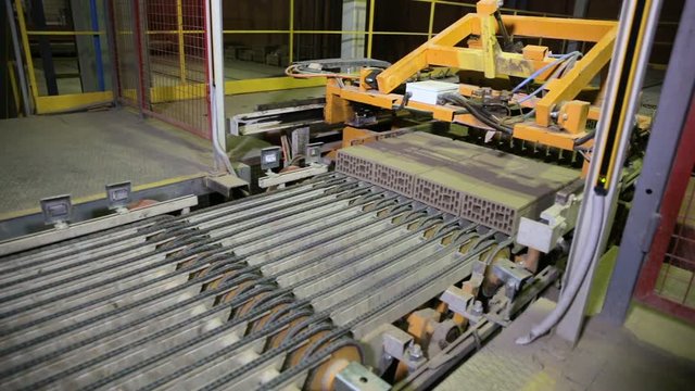 Industrial robot conveyor working at a factory, assembling goods, bricks. HD.