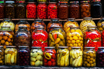 Rows of pickled vegetables in glass jars