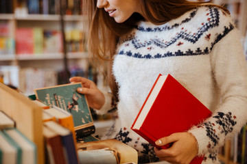 Young woman choosing books in library