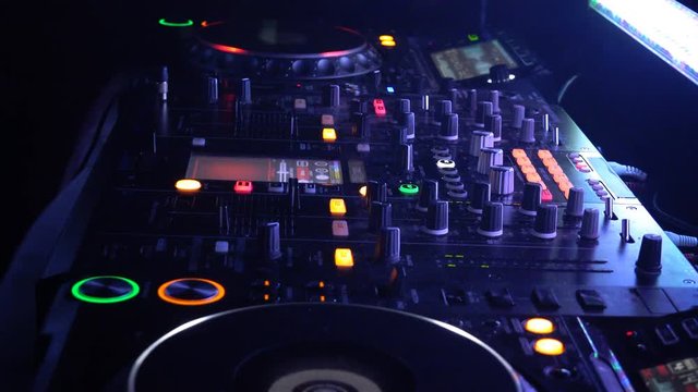 DJ behind the decks in a nightclub. DJ spinning plate. people dancing in a nightclub.