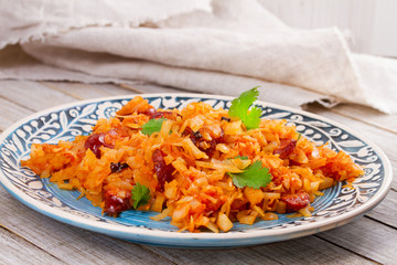 Stewed cabbage with sausages, carrot, onion and tomatoes