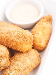 Croquetas casera junto a un cuenco con salsa. Vista superior