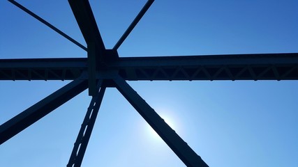 Steel structure support above the bridge on blue sky background