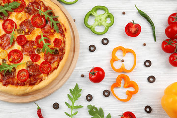 Delicious pizza with ingredients and spices on table