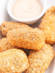 Croquetas casera junto a un cuenco con salsa. Vista superior