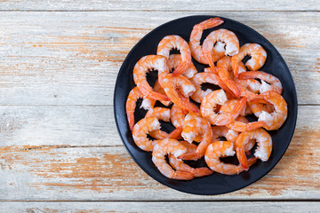boiled tails of king shrimps on black dish