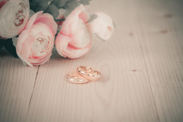 Wedding rings on wooden table with vintage tone