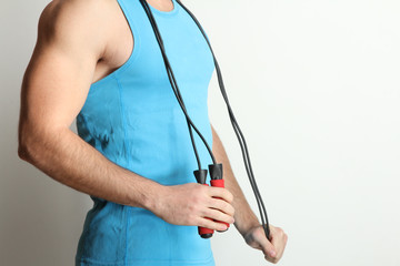 Muscular man holding a sports rope. The concept of a healthy lifestyle, sport.