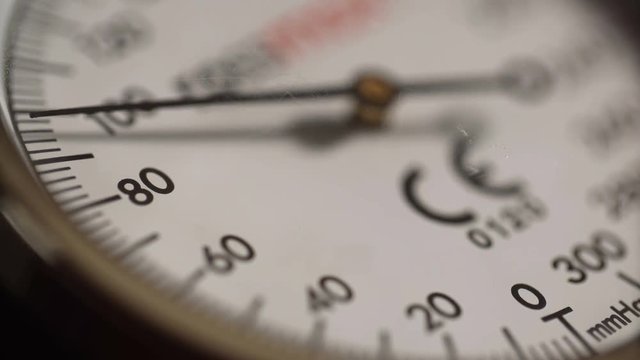 Extreme close-up nurse measures blood pressure with sphygmometer