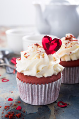 Delicious red velvet cupcakes decorated with hearts on rusty old metal background. Holiday food concept. Valentines Day.
