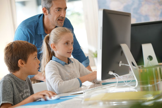 Teacher with school kids in computer laboratory