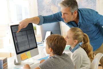 Teacher with school kids in computer laboratory