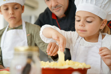 Pastry chef watching kids preparing apple pie © goodluz