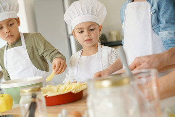 Kids in cooking class workshop preparing apple pie