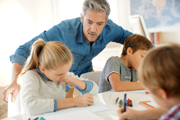Teacher with kids in class giving writing lesson