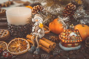 Xmas or new year composition with holiday decoration - Homemade X-mas cupcakes, sliced dried oranges on wooden background with spruce twigs. Little man figures. Christmas card