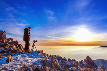 Professional photographer takes photos with camera on tripod on Deogyusan mountain.