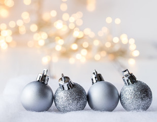 julgrans kulor i silver i förgrunden belysning ofokuserat i bakgrunden med utrmme för egen text