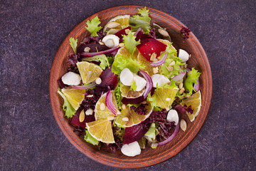 Fototapeta na wymiar Mozzarella, Orange, Beetroot, Red Onion, Nuts and Seeds Salad. View from above, top studio shot