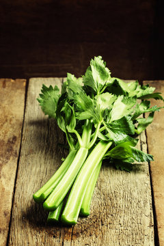 Fresh celery stalks, vintage wooden background, selective focus