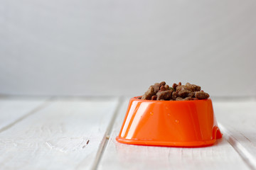 Pets food on cat bowl. Dry feed on orange bowl.
