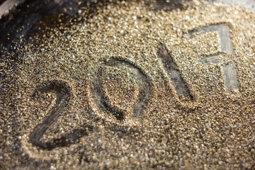 2017 new year concept. Numbers 2017 on the gold sand texture.