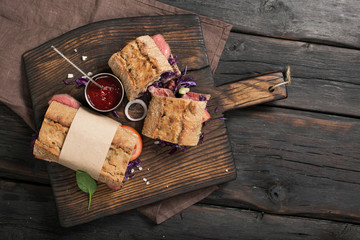 Sandwiches with meat grill on the brown old kitchen board
