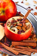Red juicy apple with assorted nuts , raisins and cinnamon