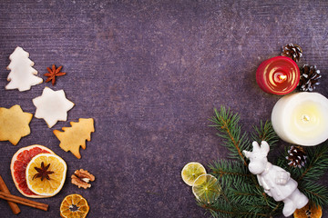 Fototapeta na wymiar Christmas background with gingerbread cookies, dried citrus and fir tree. Decorations and gift box on rustic wooden board. View from above, top studio shot