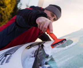 Scraping ice from the car window, ice cleaning
