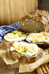 Sandwiches from homemade bread with pumpkin seeds, goat cheese, apple and onion