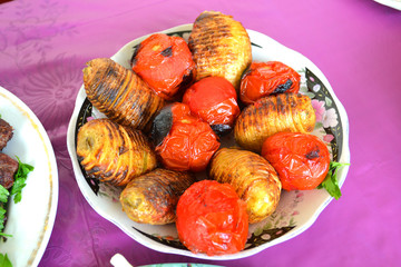 Azerbaijani skewers of potatoes and tomatoes on a plate