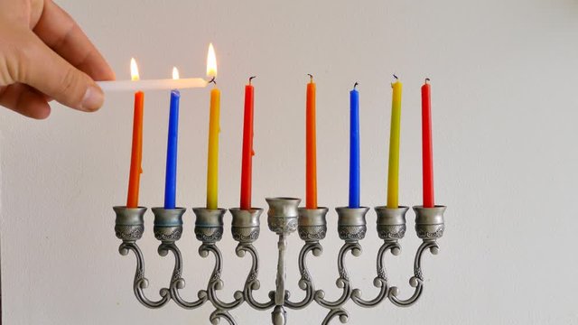 Lighting Hanukkah candles on a Jewish Menorah