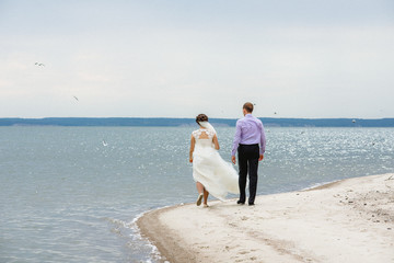 the bride and groom are on the seashore